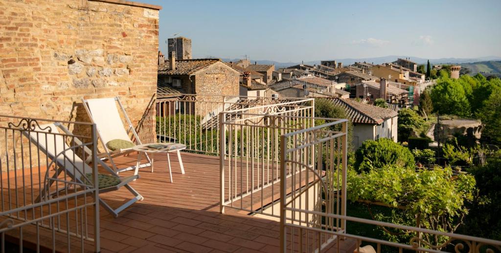 d'un balcon avec deux chaises et vue sur la ville. dans l'établissement Suite Le Palme con terrazze in centro, à San Gimignano