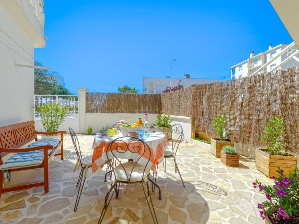 un patio avec une table et des chaises et une clôture dans l'établissement Apartment Lou Pescadou by Interhome, au Grau-du-Roi