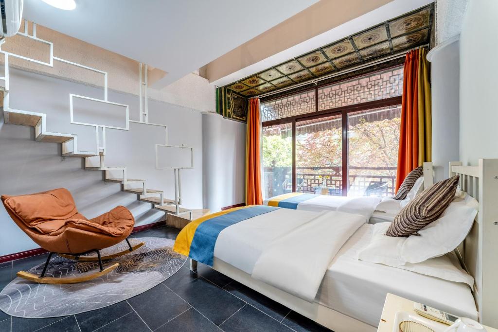 1 dormitorio con 1 cama y 1 silla frente a una ventana en Xi'an See Tang Guesthouse en Xi'an