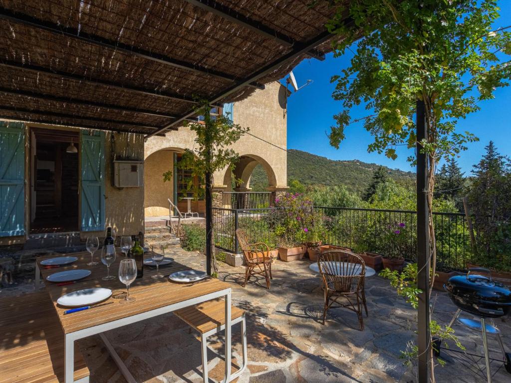 un patio avec une table et des chaises et un bâtiment dans l'établissement Holiday Home Villa Jeamic by Interhome, au Lavandou