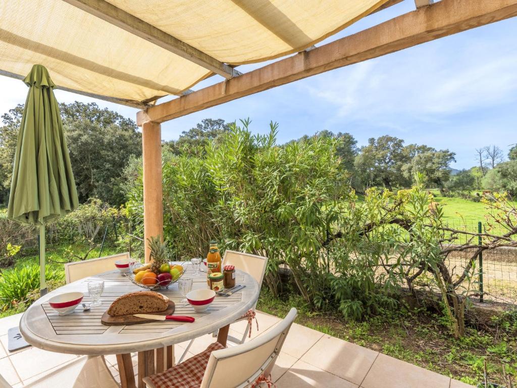 - une table et des chaises sur une terrasse avec un parasol dans l'établissement Holiday Home A Vigna by Interhome, à Sotta