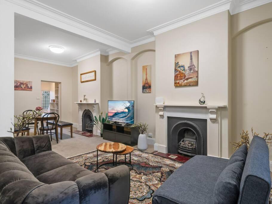 a living room with a couch and a fireplace at 4 bdrms house ICC & Darling Harbour & central & CBD & China Town in Sydney