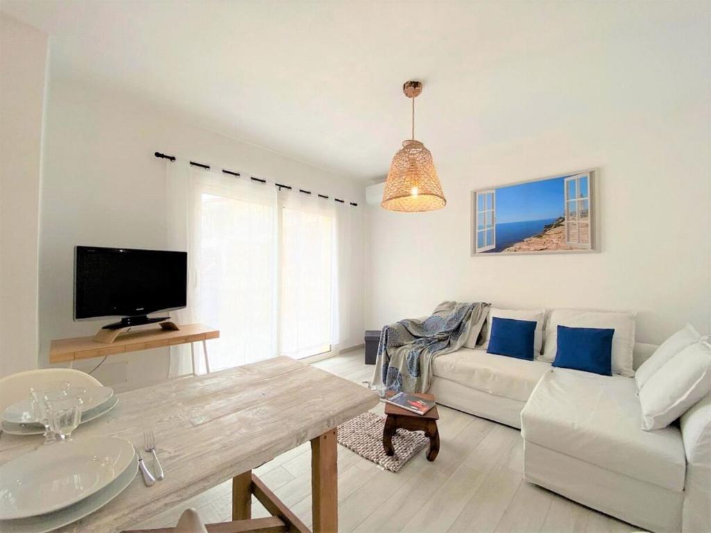 sala de estar con sofá blanco y TV en Apartment Perla dell'Isola by Interhome, en Trinità dʼAgultu