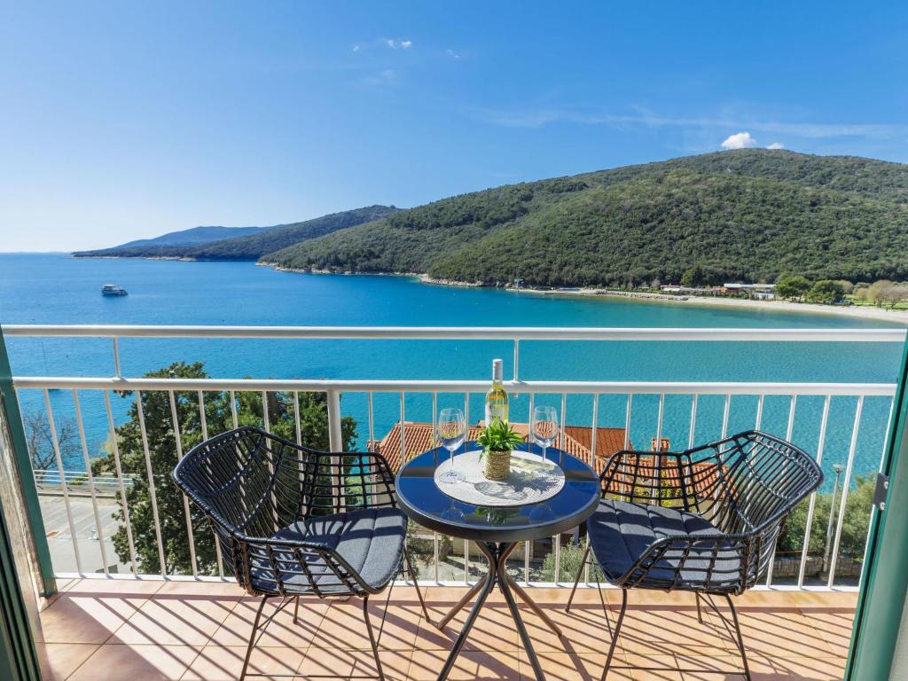 a balcony with a table and chairs and a view of the water at Apartment Acqua e sale by Interhome in Rabac