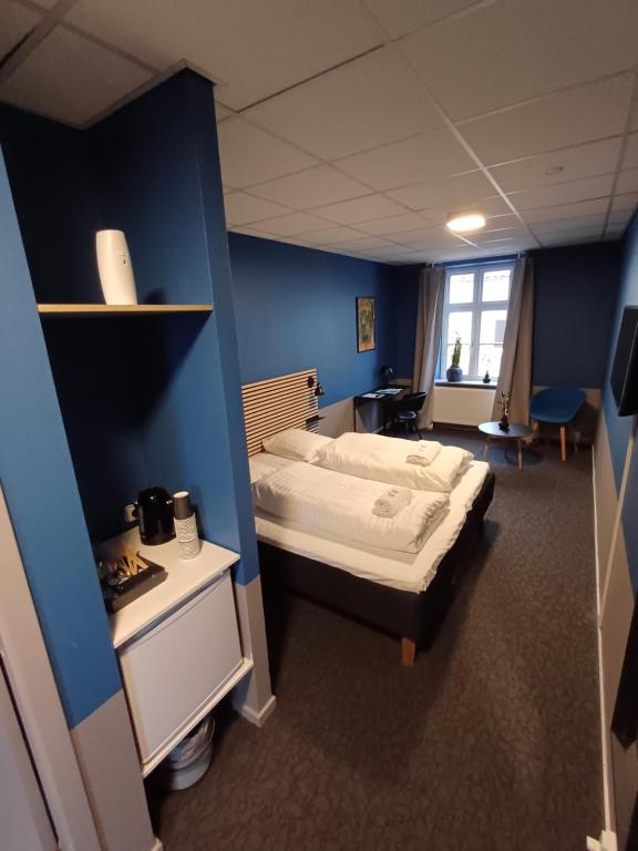 ein Schlafzimmer mit einem Bett und einer blauen Wand in der Unterkunft Room 5 On Pedestrian Street Sby - Free Parking in Sæby