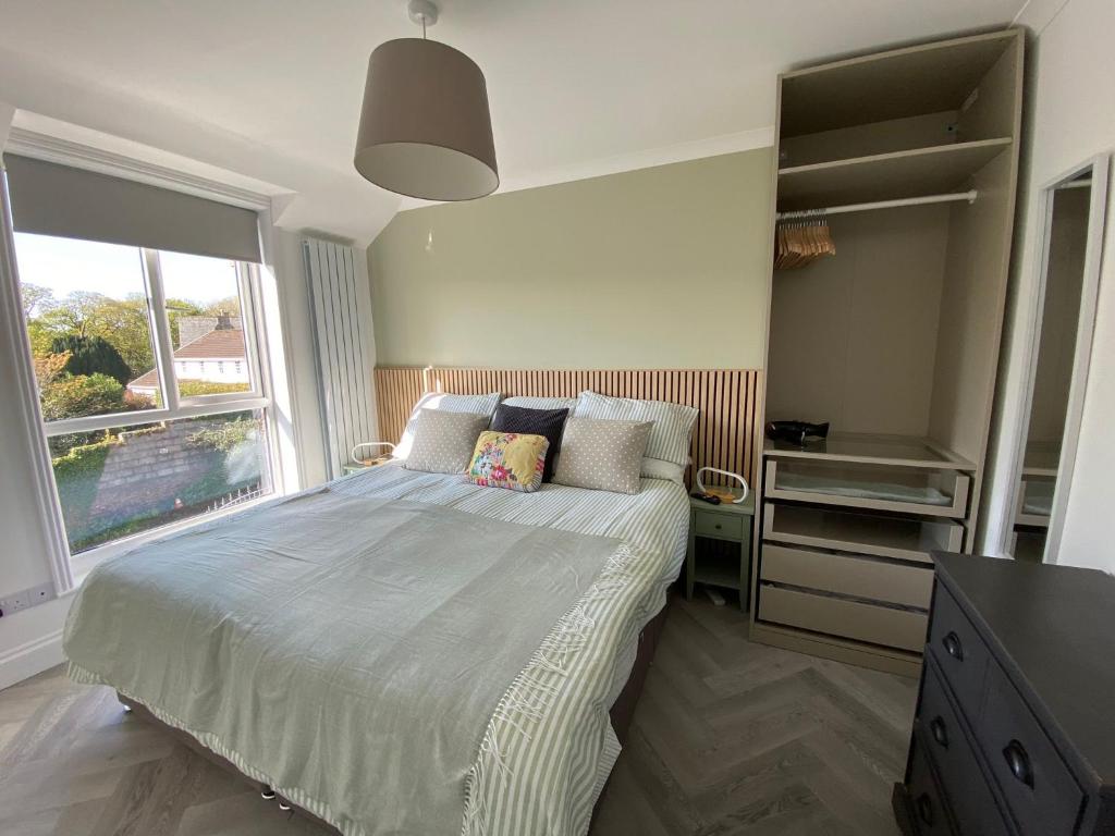 a bedroom with a bed with pillows and a window at 4 Bed House in Lovely Cornish Town in Saint Columb Major