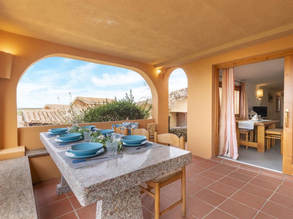 a dining room with a table with blue dishes on it at Apartment 0-1-M - Marineledda by Interhome in Golfo Aranci