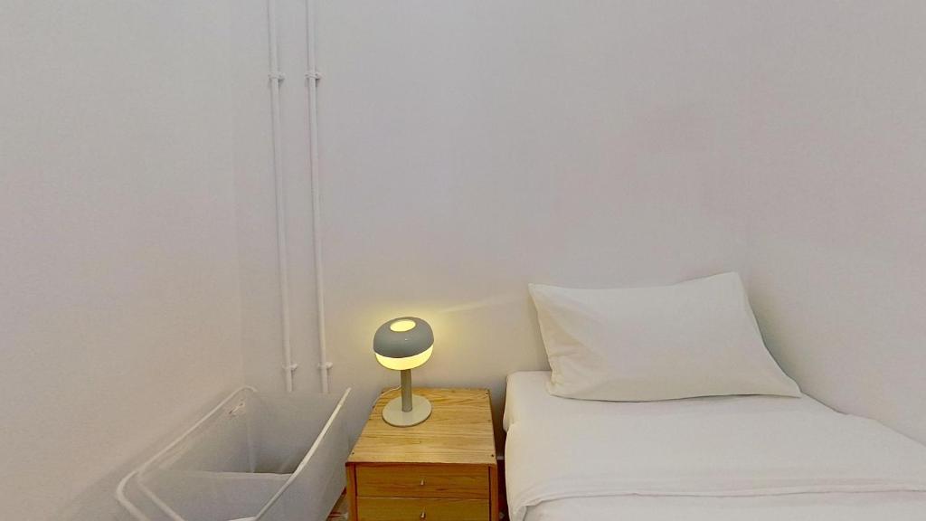 a bedroom with a bed and a lamp on a night stand at Habyt Bridges - 4 Wa In Fong Street in Hong Kong