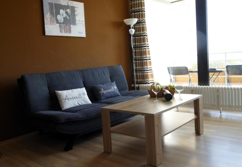 a living room with a blue couch and a coffee table at Ferienwohnung Geyersberg in Freyung