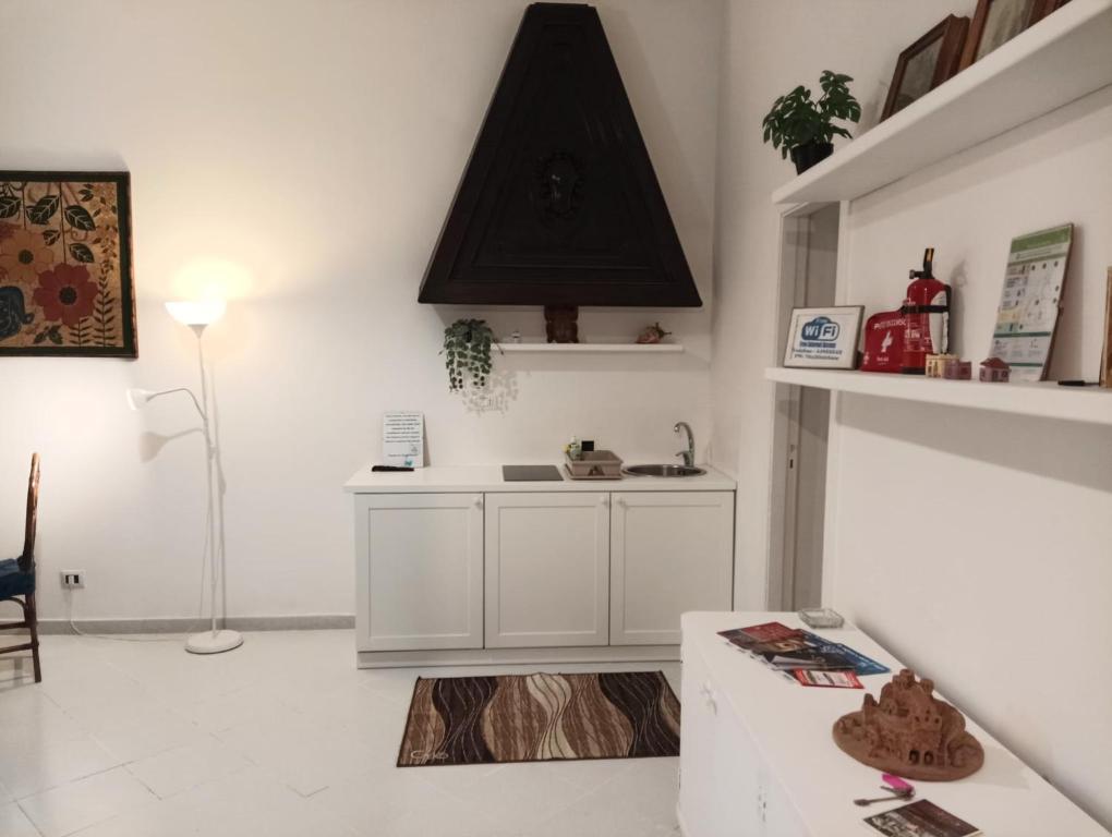 a white kitchen with a sink and a stove at Valerio's Flat in Pozzuoli