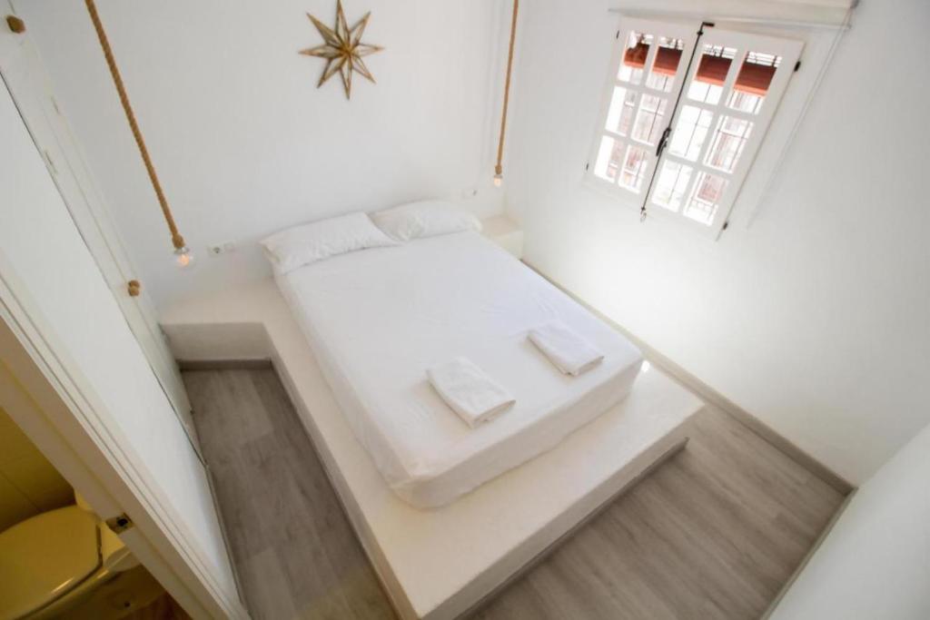 マラガにあるEl Refugio de Raquel My Happy Placeの白いベッド1台(枕2つ付)が備わる小さな客室です。
