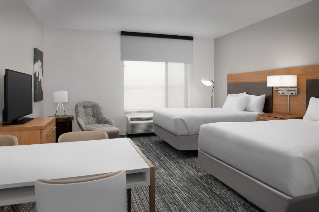 a hotel room with two beds and a tv at TownePlace Suites by Marriott Cheyenne Southwest/Downtown Area in Cheyenne