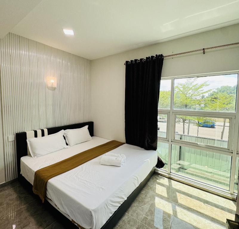 a bedroom with a bed and a large window at Rayyaz Inn in Kuala Terengganu