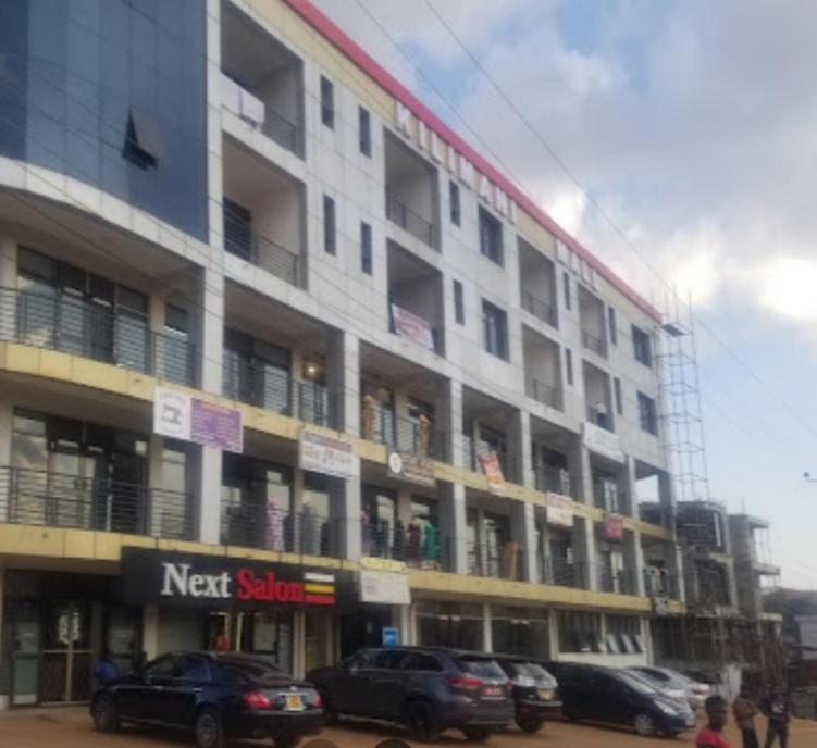 a large building with cars parked in front of it at Serene 1 Bedroom Cozy Apartment in a fancy mall in Najjera in Kampala