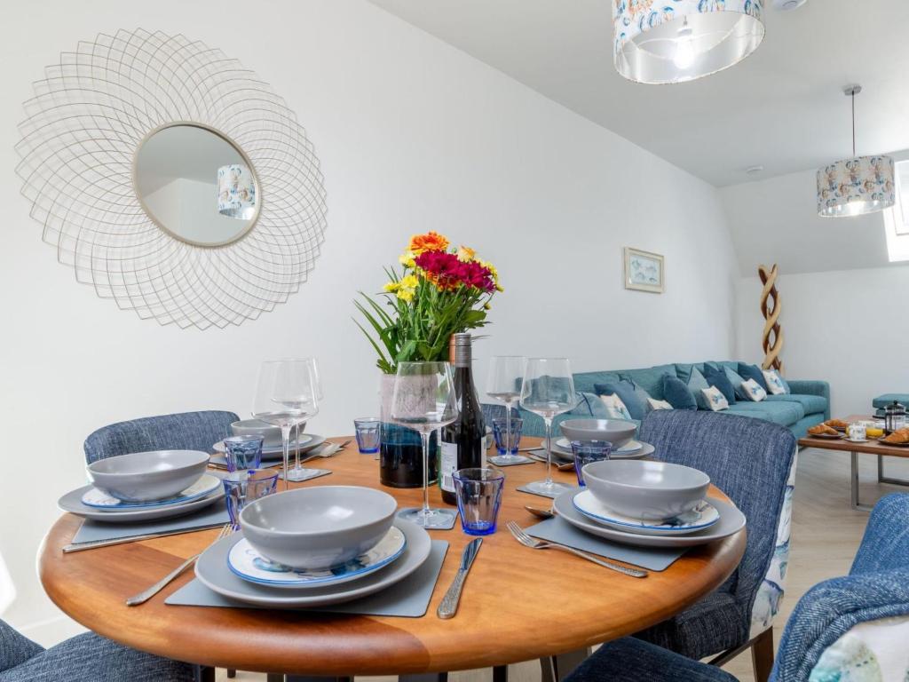 a dining room table with plates and glasses on it at Holiday Home Lobster by Interhome in Newquay