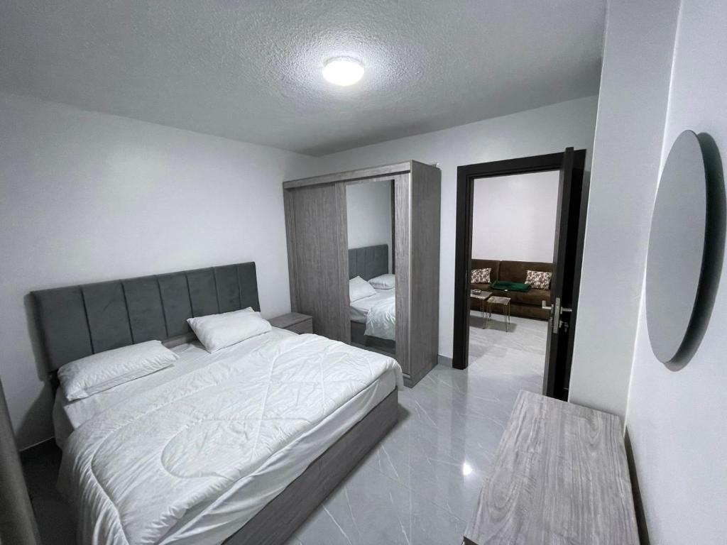 ein Schlafzimmer mit einem großen Bett und einem Spiegel in der Unterkunft شقق الريم in Ţāb Kirā‘