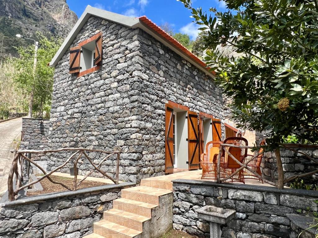 a stone house with stairs leading up to it at Traditional House in Curral das Freiras