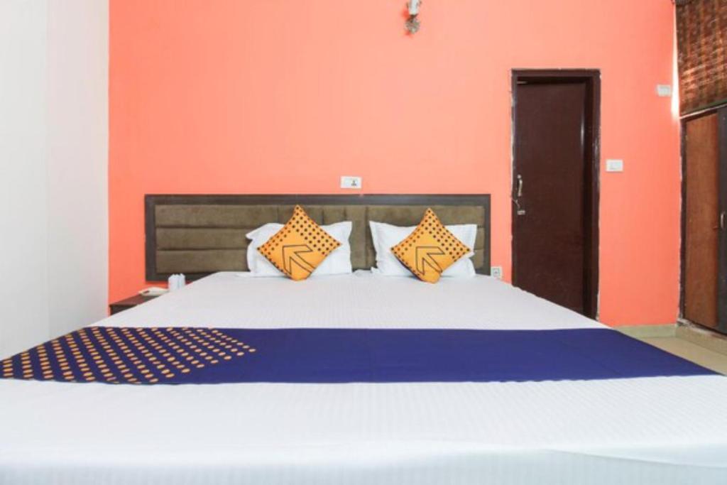 1 dormitorio con 1 cama grande y paredes de color naranja en Goroomgo Viren Pacific Agra Near Taj Mahal - Wonderfull Stay with Family, en Agra