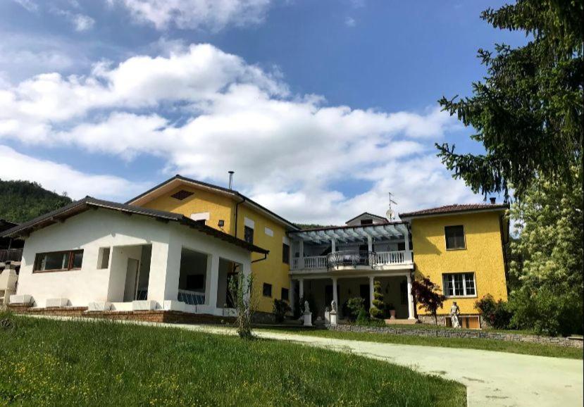 een geel en wit huis met een groene tuin bij Avventura e Relax a Bagnasco 1 in Bagnasco