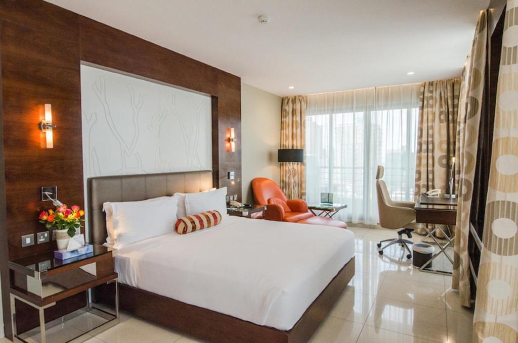 a bedroom with a large bed and a living room at Harbour View Suites in Dar es Salaam