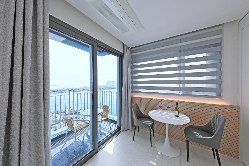 束草市的住宿－World Sky Residence Hotel，客房设有桌椅和大窗户。