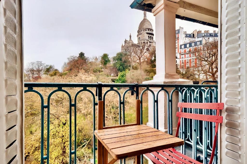 a wooden bench sitting on a balcony with a view at Amazing Sacre-Coeur views in Montmartre in Paris