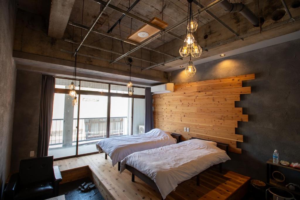 En eller flere senge i et værelse på 共用シャワーとトイレ 廃ビルリノベのデザイナーズホステル Cabin