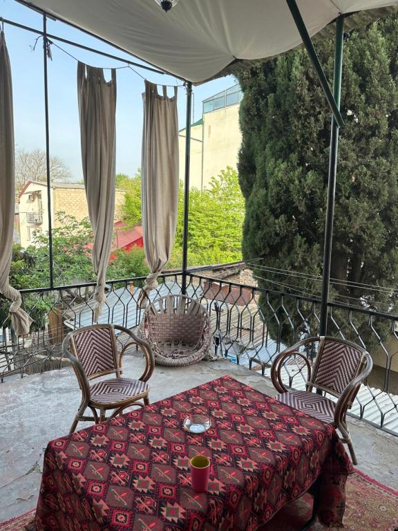 um pátio com uma mesa, cadeiras e um guarda-sol em Nina’s Sweet Home em Tbilisi