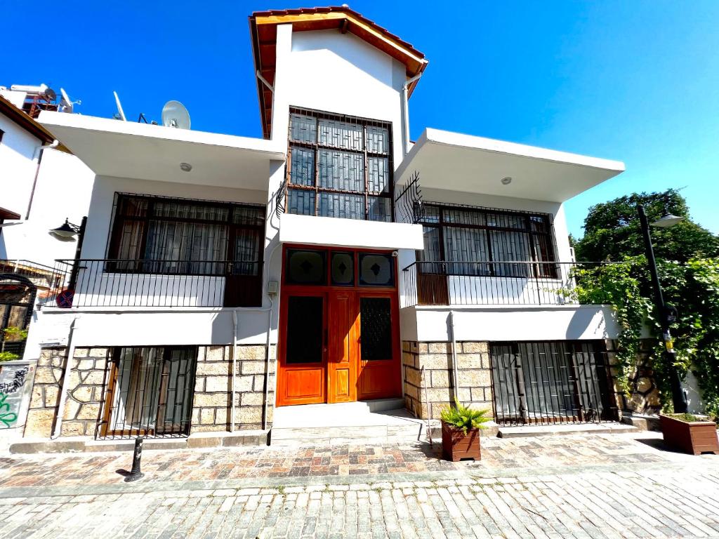 una casa con una puerta roja delante de ella en Konukzade OldTown Apart, en Antalya