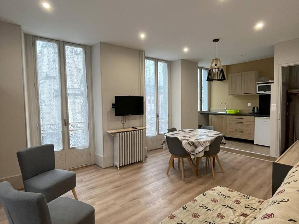 une cuisine et un salon avec une table et des chaises dans l'établissement Appartement T2 avec Balcon, Proche Thermes et Télécabine - Cauterets, 5 Pers - FR-1-234-119, à Cauterets