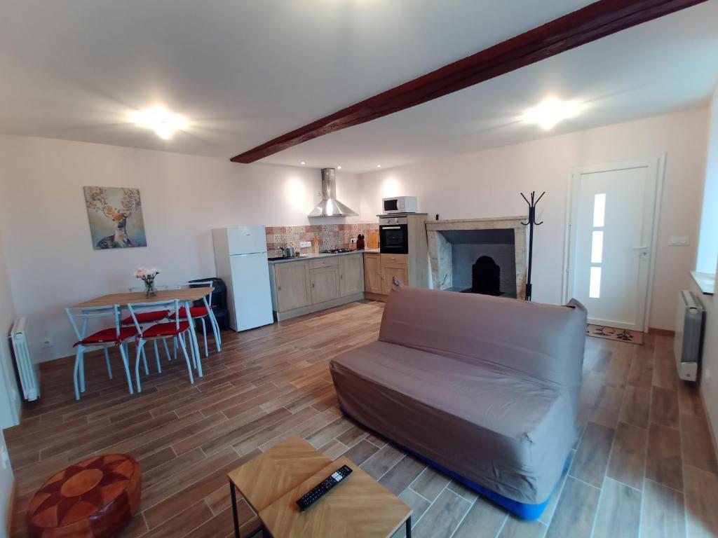 a living room with a couch and a table at Maison a la Laiterie in La Gaubretière
