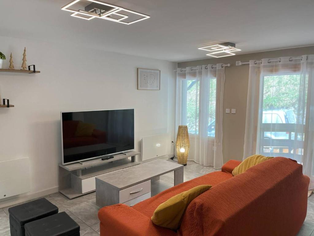 un salon avec un canapé et une télévision à écran plat dans l'établissement Appartement T4 rénové, proche centre, 3 chambres, 6/8 pers, équipé, est/ouest, dispo de suite - FR-1-234-254, à Cauterets