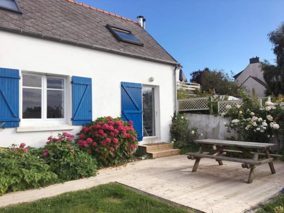 - une table de pique-nique devant une maison fleurie dans l'établissement Maison de pêcheur proche plage et activités, à Crozon