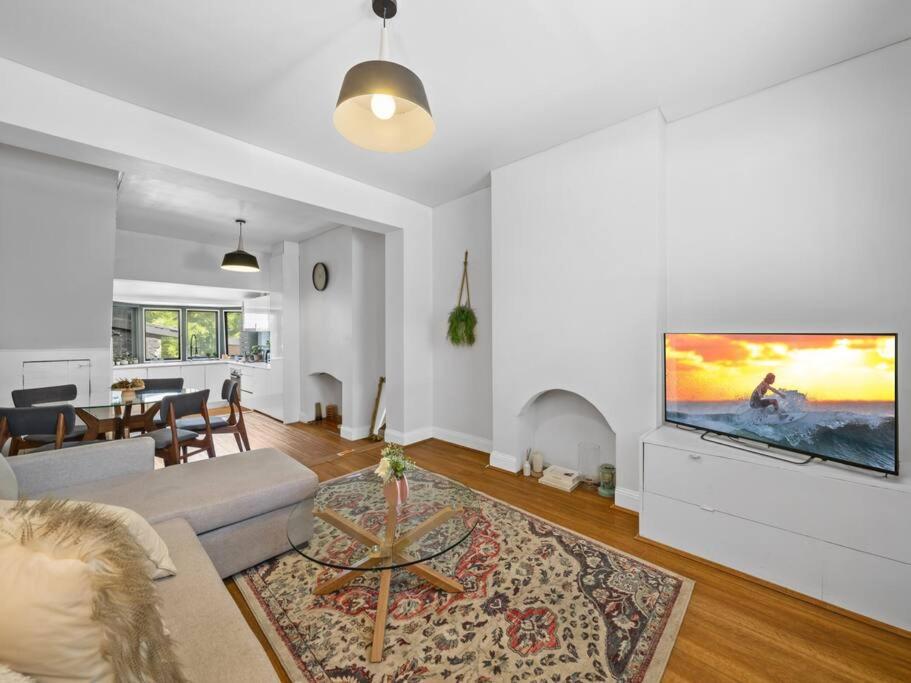 a living room with a couch and a flat screen tv at Quaint Aussie 2Br plus 1 loft - Casino & ICC & Chinatown & Darling Harbour & Fish Market in Sydney