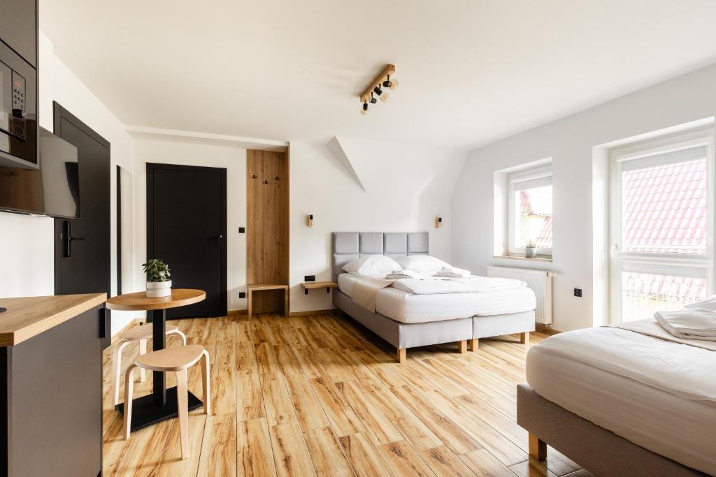sypialnia z 2 łóżkami i stołem oraz kuchnia w obiekcie Apartamenty ZakoCHata Zakopane w Zakopanem