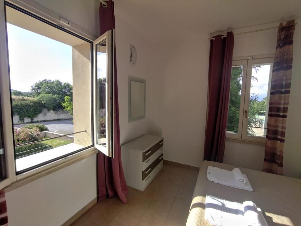 1 dormitorio con cama y ventana grande en La Torretta, en Piombino