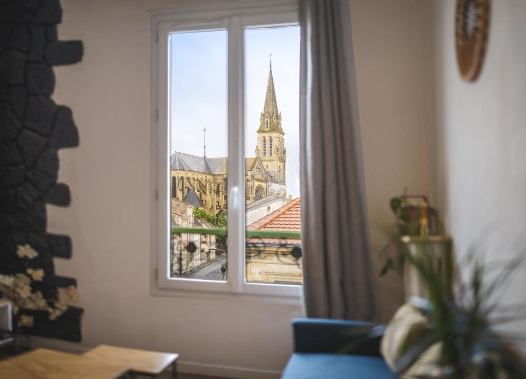 une fenêtre avec vue sur une église dans l'établissement Le J'y suis j'y reste ! - Bergerac Centre - 2 pers, à Bergerac