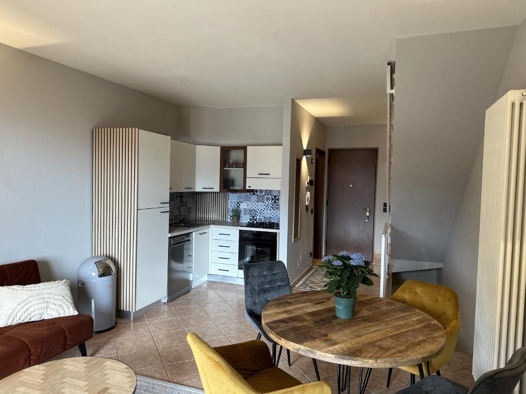 ein Wohnzimmer mit einem Tisch und einer Küche in der Unterkunft Casa Di Tino by GadraDoma in Assenza di Brenzone