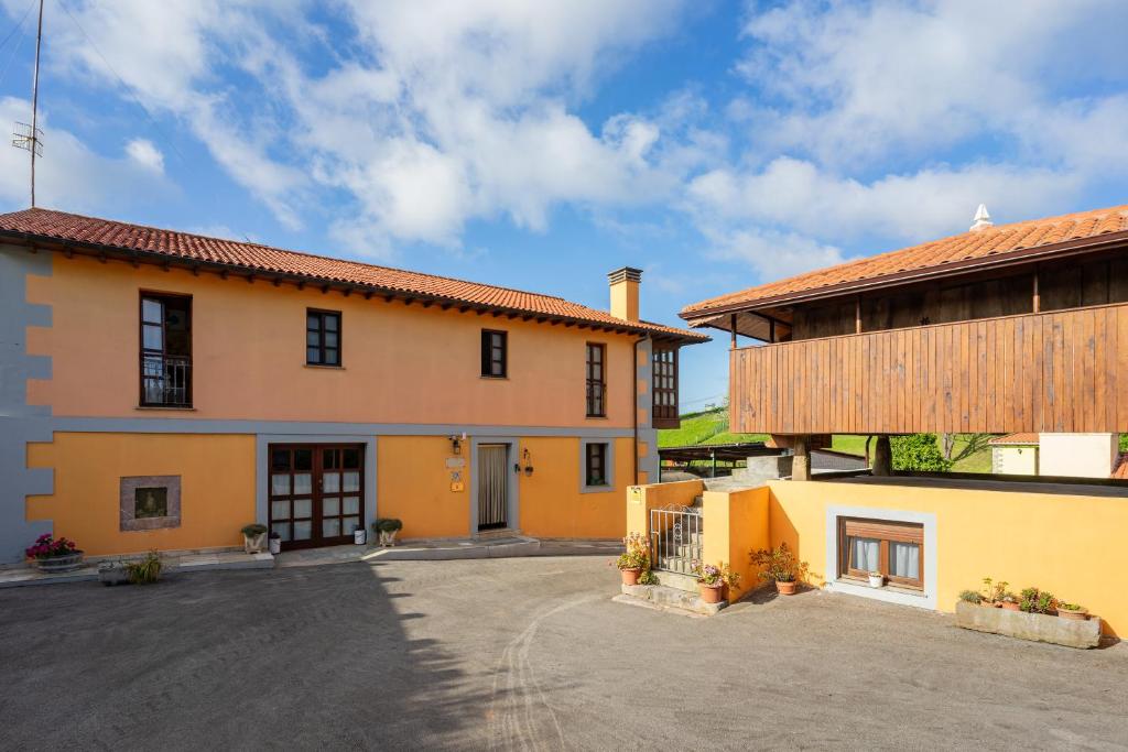 um grande edifício amarelo ao lado de uma casa em Aldea Salguero 