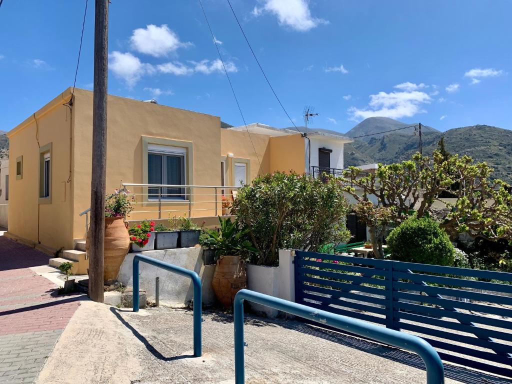 a house with a blue fence in front of it at Morea Bay View in Tourlotí