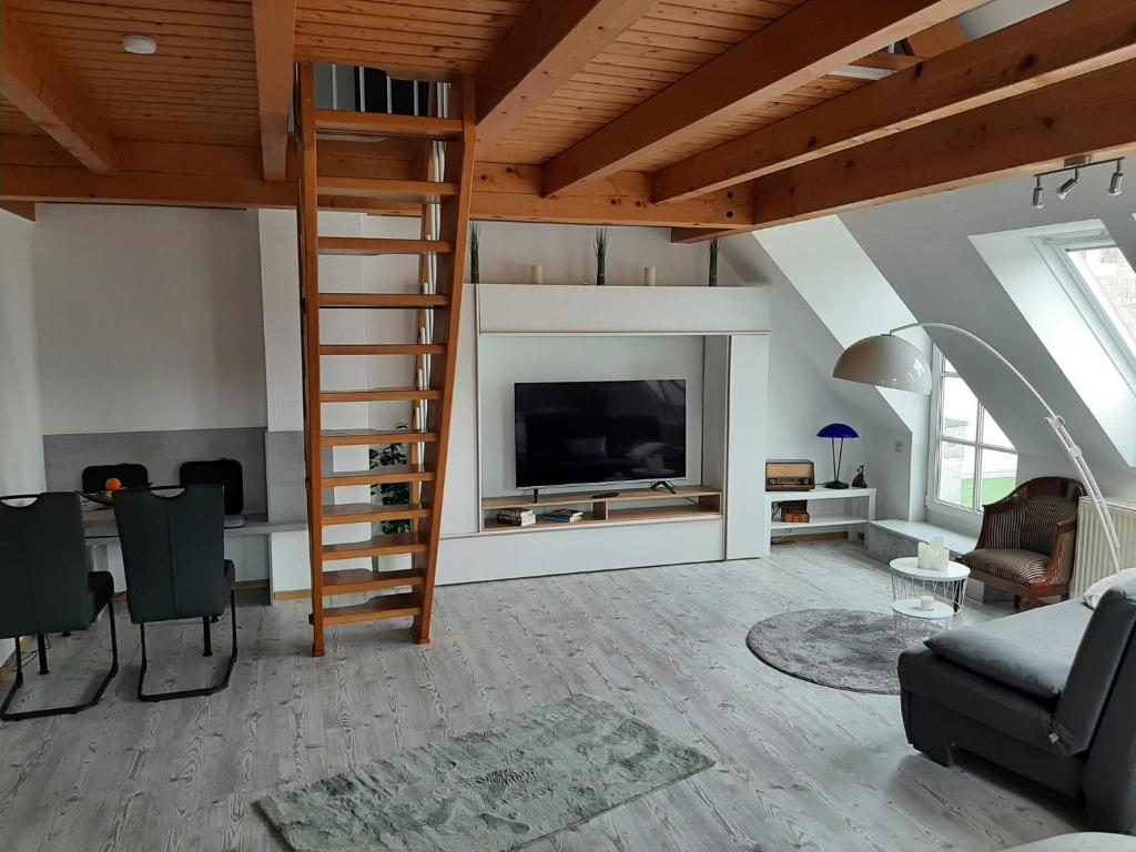 利希特瑙的住宿－FeWo Elke Lichtenau，一间带楼梯和电视的客厅