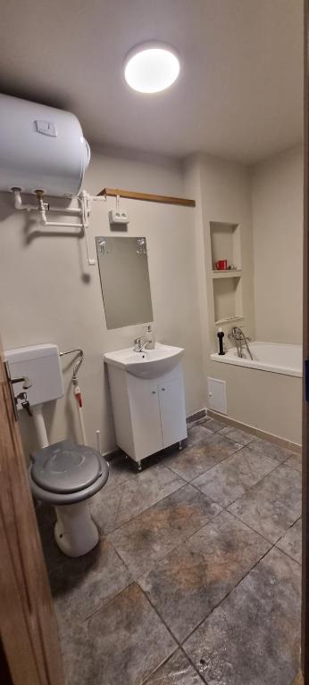 a bathroom with a toilet and a sink and a tub at Locuință rezidențială la mare in Constanţa