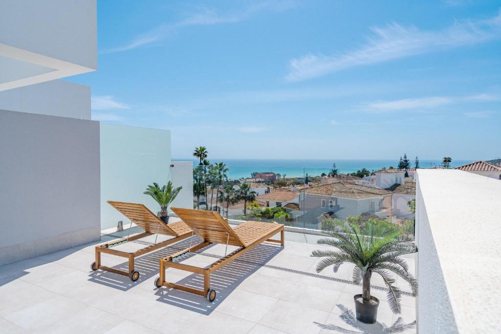 マニルバにある31 Pure South Penthouse sea views Manilvaの椅子2脚と海の景色が見えるバルコニー