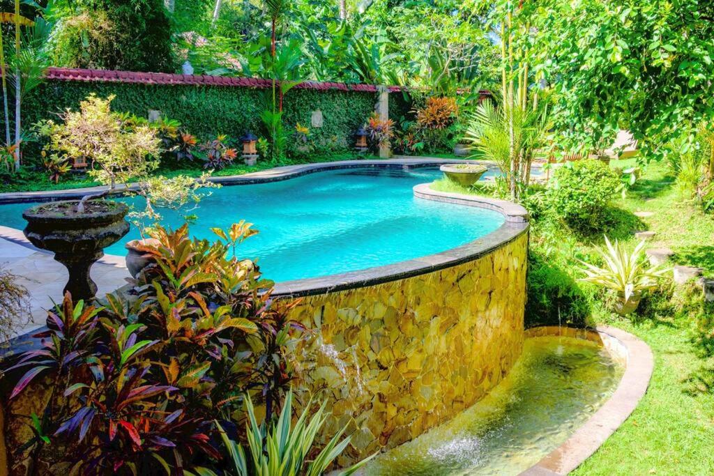 a swimming pool in the middle of a garden at Jineng 5 BR Private Pool Villa with Stunning Garden by Basma Groups in Ubud