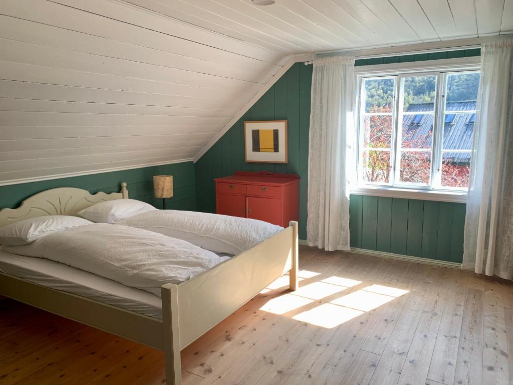 um quarto com paredes verdes e uma cama com uma janela em Guddals Tunet em Rosendal