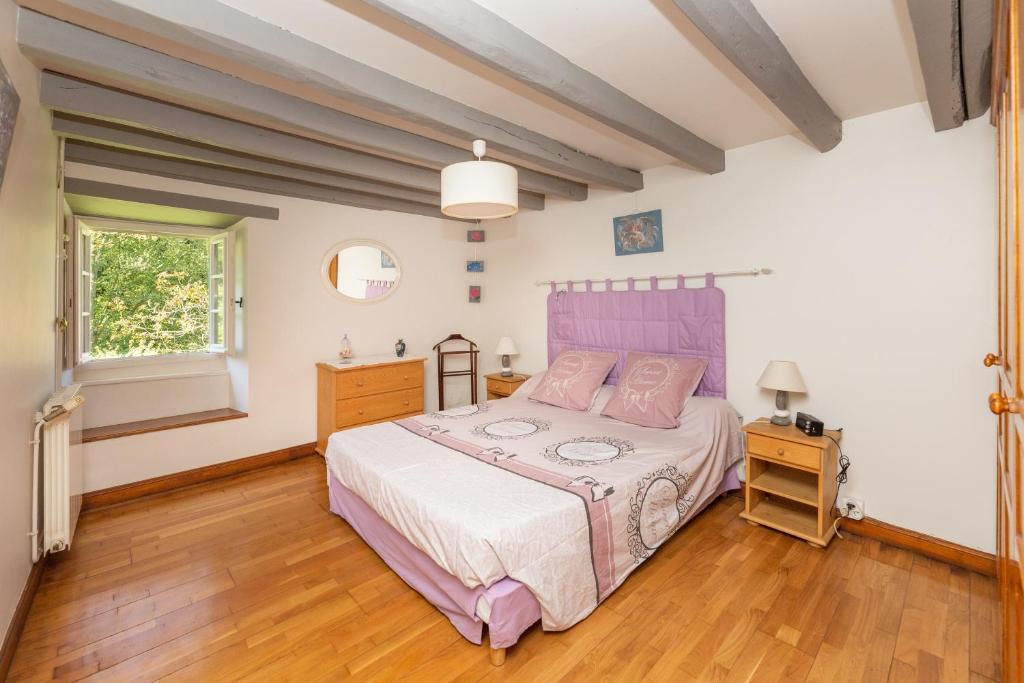 a bedroom with a pink bed and a wooden floor at L&#39;Errekaldea - Vue montagne et piscine privée in Masparraute