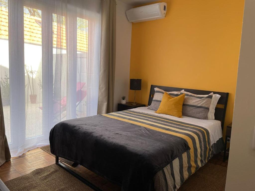 a bedroom with a bed with yellow walls and a window at 100 Contos in Porto