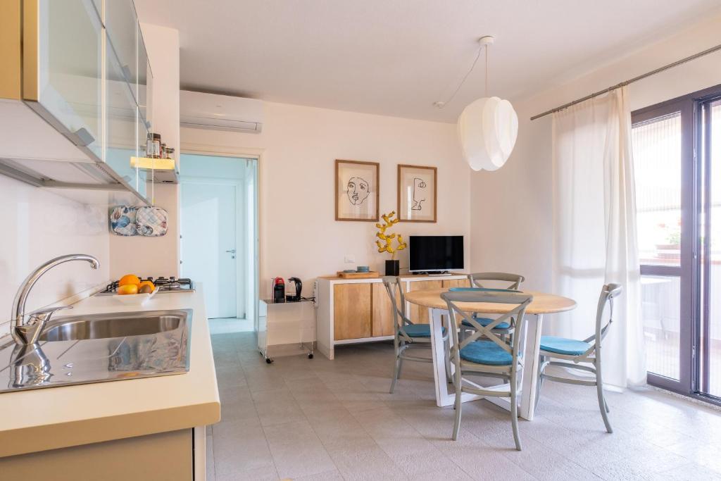 a kitchen and dining room with a table and chairs at Orosei Home Holidays - I fiori in Orosei