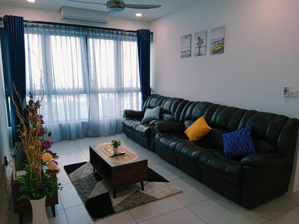 a living room with a black leather couch and a table at Preferred30 3R2B 7pax Meritus Perai in Perai