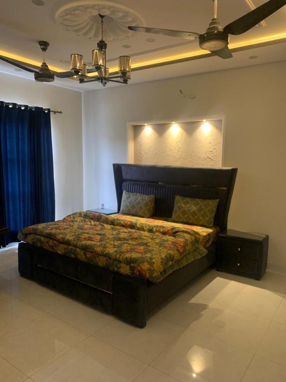 a bedroom with a bed with lights on the wall at Park View Residency 1 in Rawalpindi